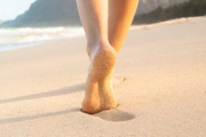 walking on the sand with small lump called plantar fibroma